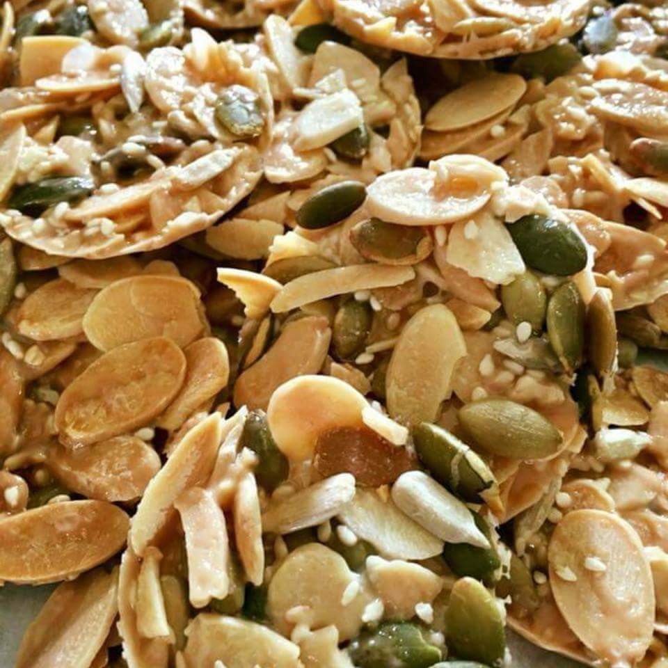 Crispy homemade Florentine cookies with nuts and seeds on wooden board
